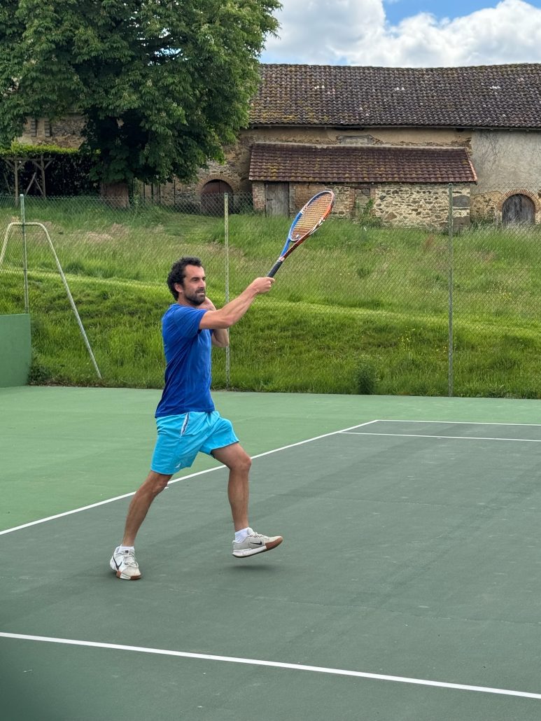 Professeur de tennis en train de jouer sur le cours.