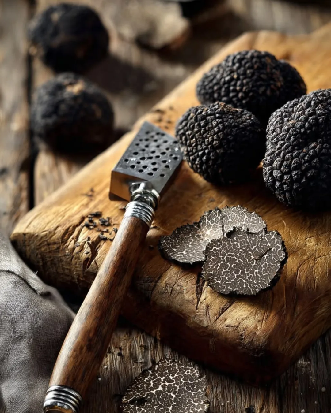 Plusieurs truffes sur une planche en bois marron.